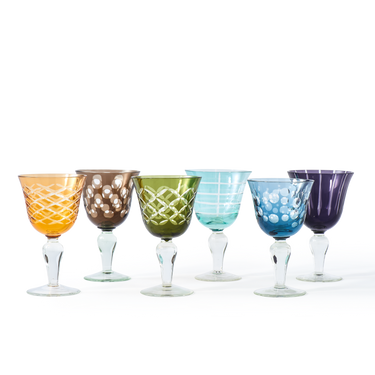 Set of six colorful glass goblets on a white background